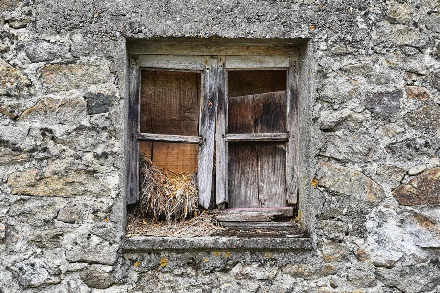 Avant : Fenêtre bois vétuste d'une maison en pierre remplacée par une fenêtre aluminium anthracite, sur la photo réelle du mur