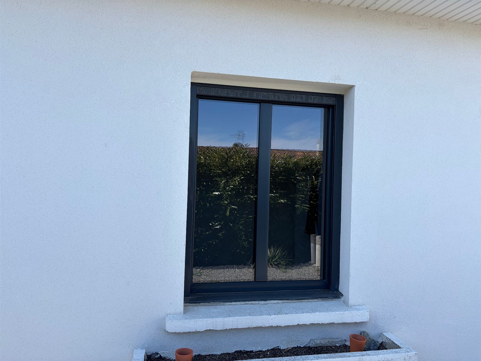 Avant : La même fenêtre déclinée en aluminium anthracite puis en finition chêne doré : le client compare les coloris sur sa façade