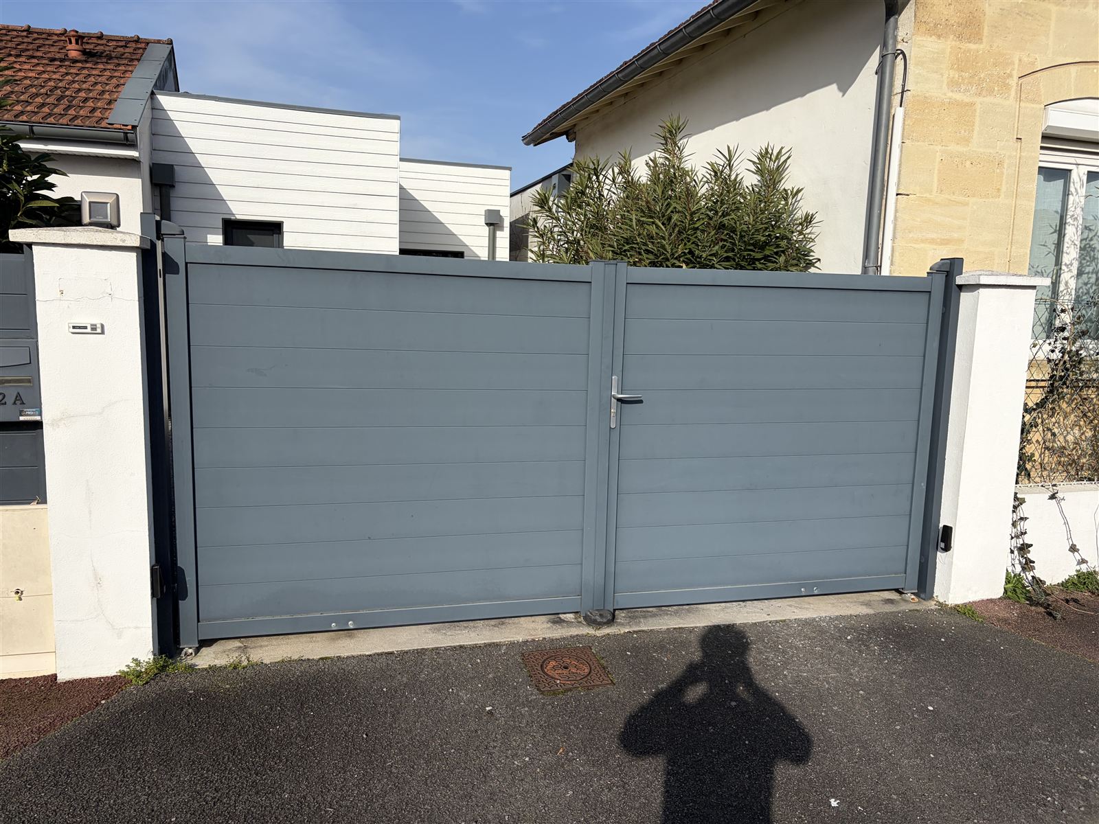 Avant : Portail plein gris remplacé par un modèle ajouré rouge, généré sur la photo réelle du client